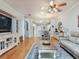 Bright living room featuring hardwood floors, ceiling fan, area rug, and decor shelving at 19337 Weymouth Dr, Land O Lakes, FL 34638
