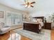 Bright main bedroom with hardwood floors, plantation shutters, ceiling fan, and comfortable chair at 19337 Weymouth Dr, Land O Lakes, FL 34638