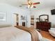 Cozy main bedroom with doorway views to bathroom and sitting room, hardwood floors and ceiling fan at 19337 Weymouth Dr, Land O Lakes, FL 34638