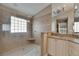 Well lit bathroom featuring a walk-in shower with a glass block window and granite countertops at 2017 S Pebble Beach Blvd, Sun City Center, FL 33573