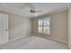 Bright bedroom featuring neutral walls, carpet flooring, and a window with plantation shutters at 2017 S Pebble Beach Blvd, Sun City Center, FL 33573