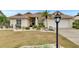 Inviting single-story home featuring a tile roof, two-car garage, manicured lawn, and mature palm trees at 2017 S Pebble Beach Blvd, Sun City Center, FL 33573