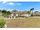 Well-maintained single-story home featuring mature trees, lush landscaping, and a two-car garage at 2017 S Pebble Beach Blvd, Sun City Center, FL 33573