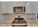 Close up view of stainless steel oven and microwave with matching backsplash and granite countertops at 2017 S Pebble Beach Blvd, Sun City Center, FL 33573