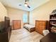 Comfortable bedroom featuring wood floors, a ceiling fan, and natural light at 21422 Draycott Way, Land O Lakes, FL 34637