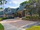 View of the clubhouse entrance featuring a covered drop off area, stone accents, and landscaping at 21422 Draycott Way, Land O Lakes, FL 34637