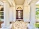 Inviting front entryway with columns, tile floor and stylish front door at 21422 Draycott Way, Land O Lakes, FL 34637