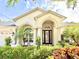 Welcoming single-story home with an arched entryway and colorful landscaping at 21422 Draycott Way, Land O Lakes, FL 34637