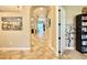 Long hallway featuring tiled floors, arched doorways, decorative painting and neutral walls at 21422 Draycott Way, Land O Lakes, FL 34637