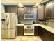 Modern kitchen featuring stainless steel appliances, granite countertops and dark wood cabinets at 21422 Draycott Way, Land O Lakes, FL 34637