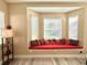 Bright living room featuring a window seat with a red cushion and decorative pillows at 21422 Draycott Way, Land O Lakes, FL 34637