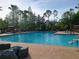Large community pool with brick paver deck and several people swimming and enjoying themselves at 21422 Draycott Way, Land O Lakes, FL 34637