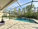 Large pool area featuring a screened enclosure, waterfall feature, and patio area for outdoor living at 21422 Draycott Way, Land O Lakes, FL 34637