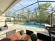 Outdoor pool area featuring a screened enclosure, waterfall feature, and comfortable patio seating at 21422 Draycott Way, Land O Lakes, FL 34637