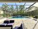 Large screened-in pool area featuring a waterfall, lounge chairs, and lush landscaping for privacy at 21422 Draycott Way, Land O Lakes, FL 34637