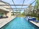 Relaxing screened-in pool area featuring a waterfall feature, outdoor seating and lush landscaping at 21422 Draycott Way, Land O Lakes, FL 34637