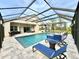 Inviting screened pool with sun loungers, tiled decking and a relaxing waterfall feature at 21422 Draycott Way, Land O Lakes, FL 34637