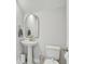 Modern powder room with a pedestal sink, sleek mirror, and neutral color palette, creating a clean and elegant space at 2190 Fairway S Ave, St Petersburg, FL 33712