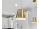Close-up of pendant lighting in a bright, modern kitchen with white cabinets and countertops at 2190 Fairway S Ave, St Petersburg, FL 33712