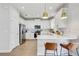 Contemporary kitchen featuring stainless steel appliances, white cabinetry, quartz countertops, and bar seating with brass pendant lighting at 2190 Fairway S Ave, St Petersburg, FL 33712