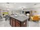 Kitchen island boasts granite countertops and a stainless steel sink, seamlessly connecting to the open-concept living space at 233 Cascade Bend Dr, Ruskin, FL 33570