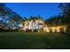 Expansive backyard at dusk, adorned with tropical palm trees and lush landscaping at 2501 S Dundee St, Tampa, FL 33629