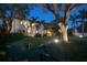 Inviting backyard featuring a cozy seating area and lush landscaping illuminated with landscape lighting at dusk at 2501 S Dundee St, Tampa, FL 33629