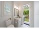 Bright bathroom featuring a modern vanity, marble floors, and an open doorway to the outdoors at 2501 S Dundee St, Tampa, FL 33629