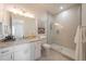 Modern bathroom featuring a glass-enclosed shower, granite countertop, and stylish white cabinetry at 2501 S Dundee St, Tampa, FL 33629