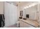 Bright bathroom featuring a granite vanity top, framed mirror, and shower with white curtain at 2501 S Dundee St, Tampa, FL 33629