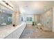 Luxurious bathroom featuring a soaking tub, a glass-enclosed shower, and double marble vanity at 2501 S Dundee St, Tampa, FL 33629