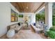 Inviting covered patio with cushioned seating, wood ceiling, and outdoor TV at 2501 S Dundee St, Tampa, FL 33629