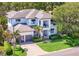 Beautiful two-story home with well-manicured lawn, mature trees, and a paver driveway at 2501 S Dundee St, Tampa, FL 33629