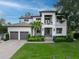 Stunning two-story home with a well-manicured lawn, palm trees, and a spacious three-car garage at 2501 S Dundee St, Tampa, FL 33629