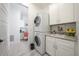 Functional laundry room with stacked washer and dryer, ample counter space, and storage cabinets at 2501 S Dundee St, Tampa, FL 33629