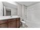 Bright bathroom with dark cabinets, neutral tile flooring, and shower and bathtub at 2525 Arbor Wind Dr, Lutz, FL 33558