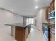 Open-concept kitchen featuring stainless steel appliances, granite countertops, and an island with seating at 2525 Arbor Wind Dr, Lutz, FL 33558