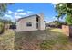 View of backyard with a chimney, lawn, and screened patio perfect for outdoor enjoyment at 2719 Cypress Hollow Ct, New Port Richey, FL 34655