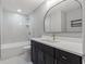 Stylish bathroom with a marble tiled shower, modern vanity, brushed gold faucet, and ample lighting at 2719 Cypress Hollow Ct, New Port Richey, FL 34655