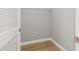 Walk-in closet features wood-look flooring and white shelving unit at 2719 Cypress Hollow Ct, New Port Richey, FL 34655