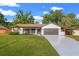 Inviting single-story home with a two-car garage, manicured lawn, and attractive exterior details at 2719 Cypress Hollow Ct, New Port Richey, FL 34655