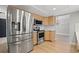 Well-equipped kitchen showcasing stainless steel appliances, light wood cabinets, and modern fixtures at 2719 Cypress Hollow Ct, New Port Richey, FL 34655
