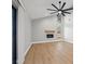 Open living room features wood-look flooring, fireplace, and a modern ceiling fan at 2719 Cypress Hollow Ct, New Port Richey, FL 34655