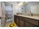 Bathroom featuring a double vanity with dark wood cabinets and a shower with an animal-themed curtain at 29002 Trevi Pl, Wesley Chapel, FL 33543