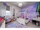 Charming bedroom with a decorative canopy bed, purple accents, and whimsical cloud-themed wallpaper at 29002 Trevi Pl, Wesley Chapel, FL 33543