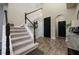 Bright foyer features wood-look tile floors, a carpeted staircase, and black paneled interior doors at 29002 Trevi Pl, Wesley Chapel, FL 33543