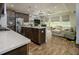 Open-concept kitchen with dark wood cabinets, stainless steel appliances, and a seamless flow to the living room at 29002 Trevi Pl, Wesley Chapel, FL 33543
