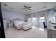 Spacious main bedroom with a tray ceiling features carpet, a ceiling fan, and bright natural light at 29002 Trevi Pl, Wesley Chapel, FL 33543