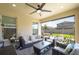 Covered patio with comfortable wicker furniture and a ceiling fan, perfect for outdoor relaxation and entertainment at 29002 Trevi Pl, Wesley Chapel, FL 33543