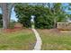 This home features a stone path leading to a gate, surrounded by lush greenery at 3014 Ashland Ter, Clearwater, FL 33761